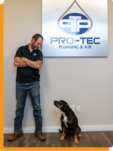 HVAC and plumbing technician standing against a white wall in Pro-Tec's office.