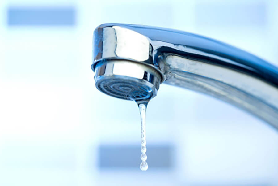 Dripping kitchen faucet as a sign of plumbing maintenance needs