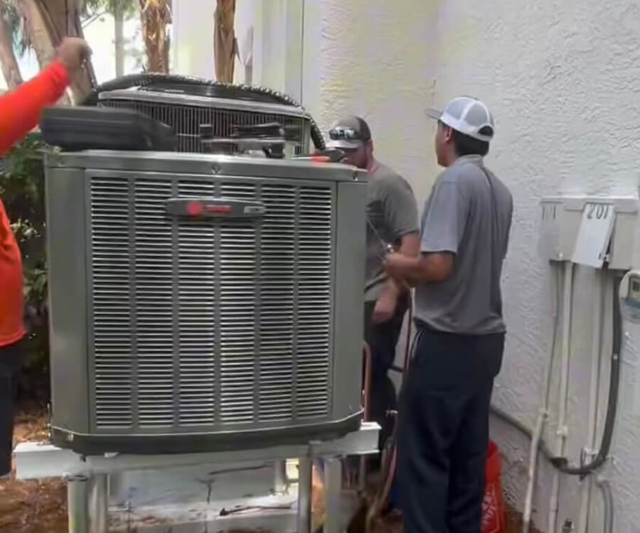 Technicians installing a high-efficiency air conditioning system with smart controls