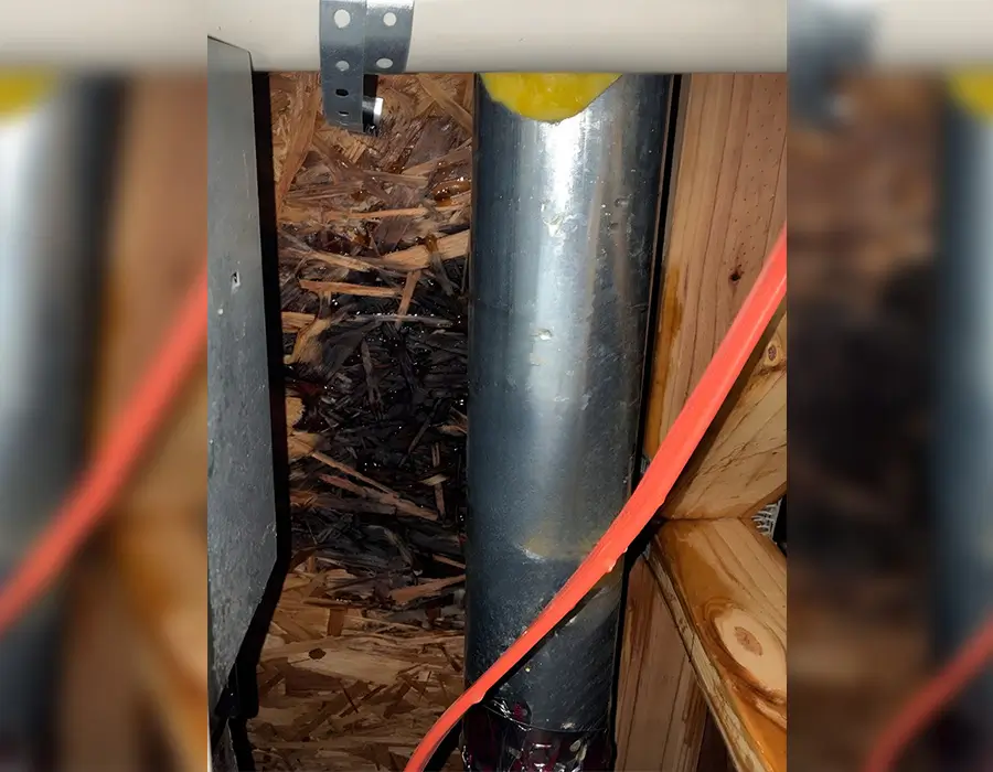 Water-damaged wood around plumbing pipes before holiday maintenance