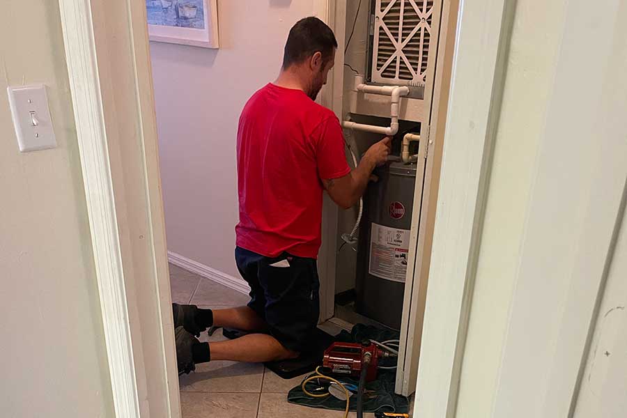 PRO-TEC technician installing a water heater in a Naples FL home utility closet