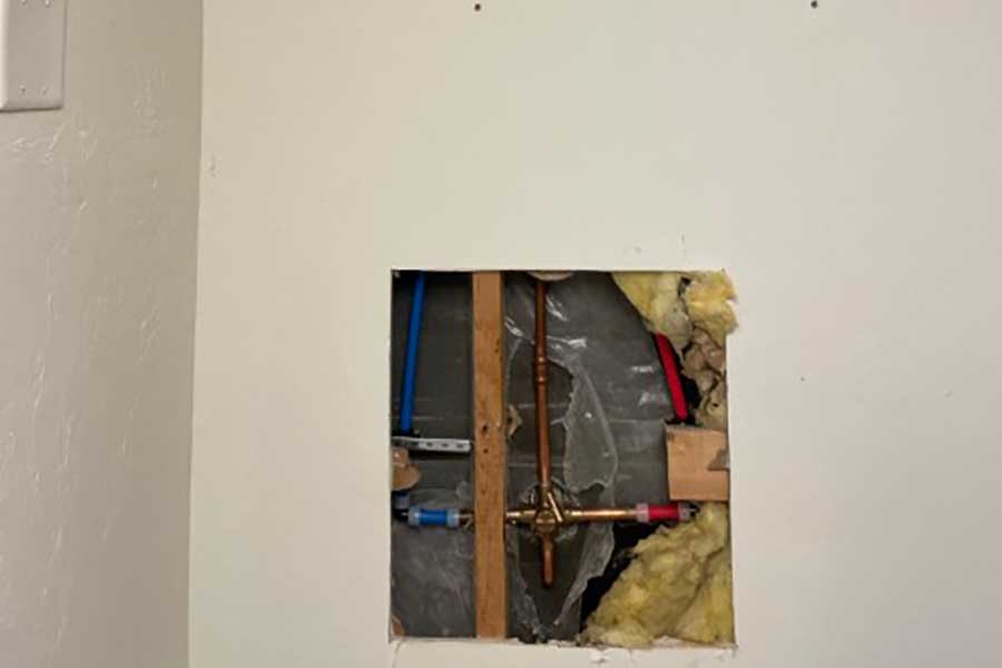 Wall opened to install new plumbing lines during home repiping in Naples FL