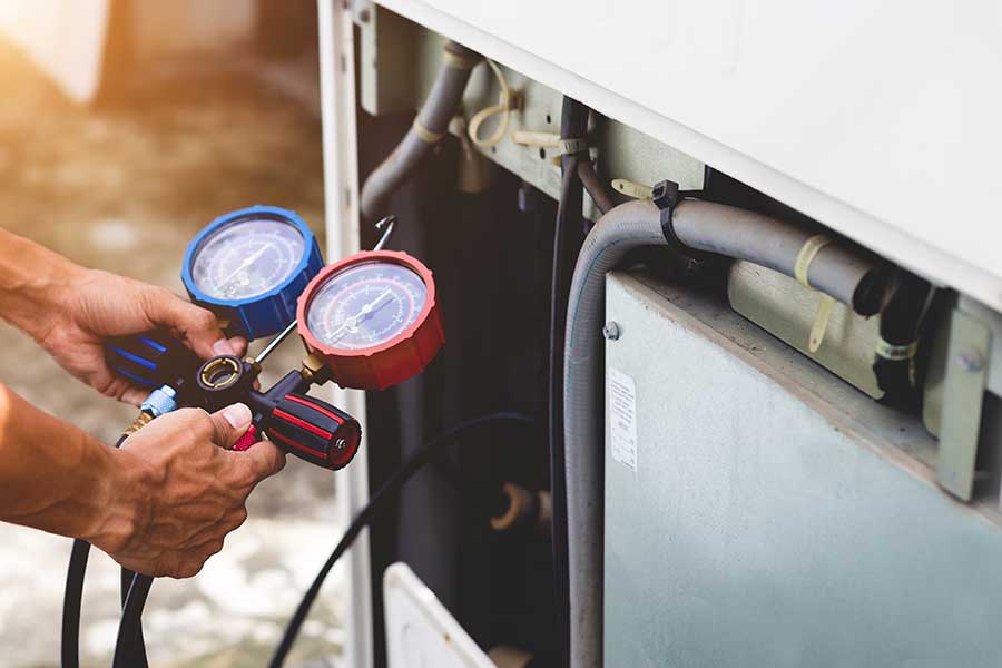 HVAC repair technician testing refrigerant levels in an AC system