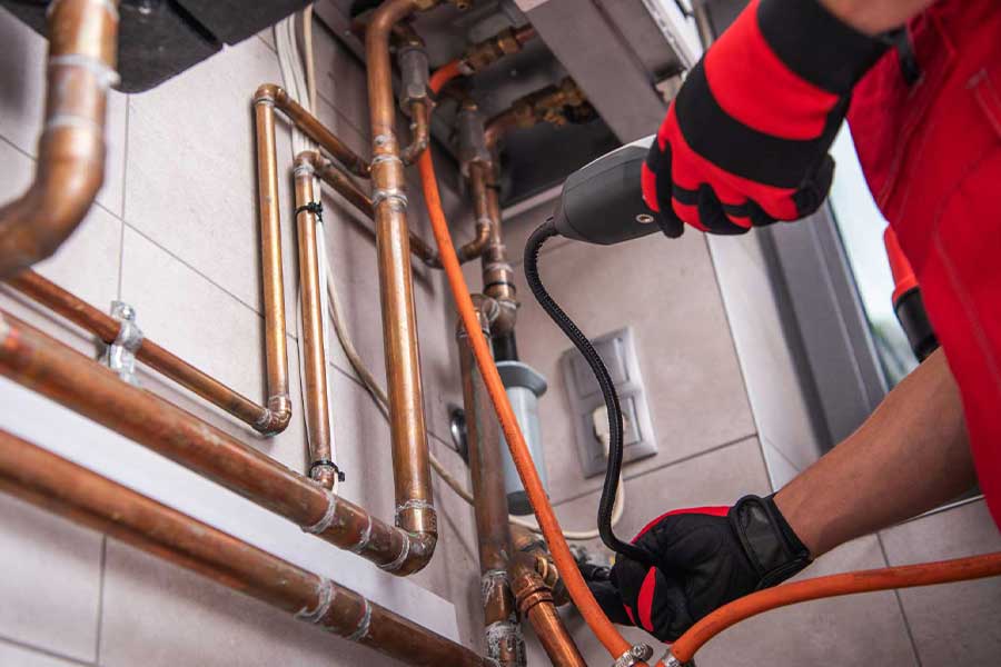 Technician inspecting gas lines for leaks in Naples FL home