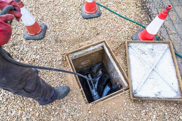 Plumber performing underground drain maintenance in Naples, FL