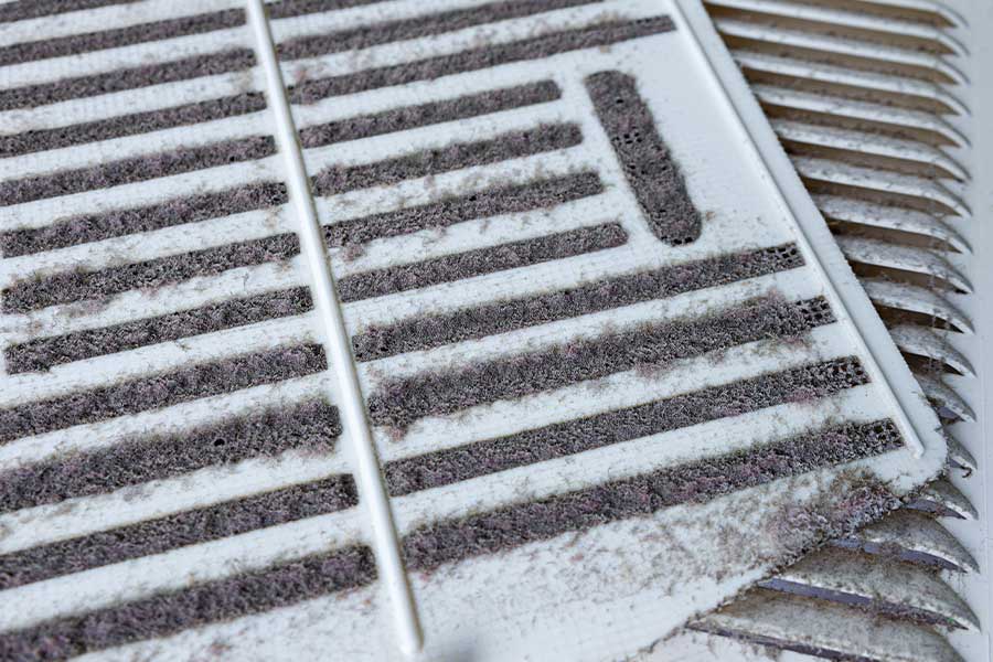 Dust-covered air filter showing signs a home may need air duct cleaning