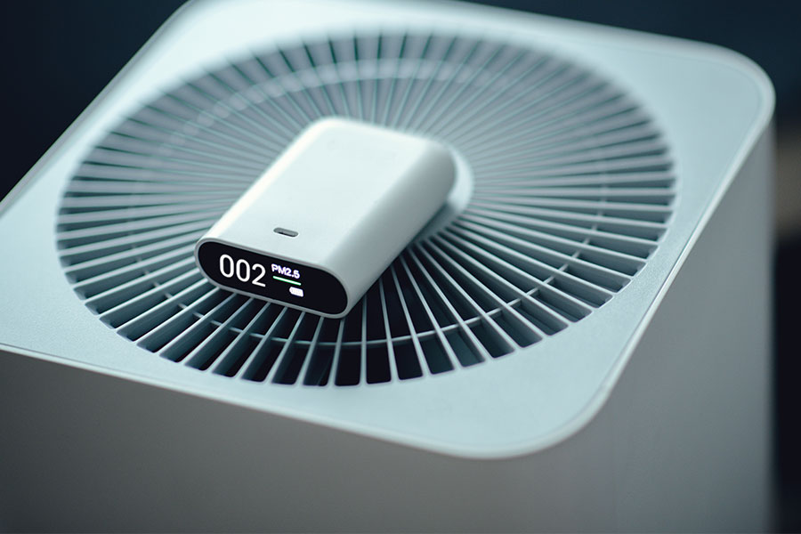 Indoor air quality device displaying PM2.5 readings on top of an air purifier