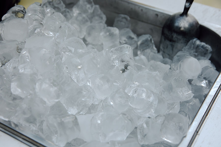 Commercial ice maker machine with clear ice cubes in the storage tray
