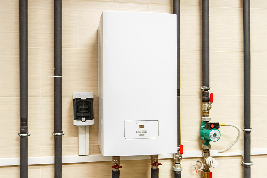 Indoor tankless water heater installed with visible plumbing and valve connections