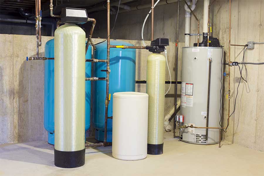 Home water treatment setup with softener tanks, storage tank, and water heater