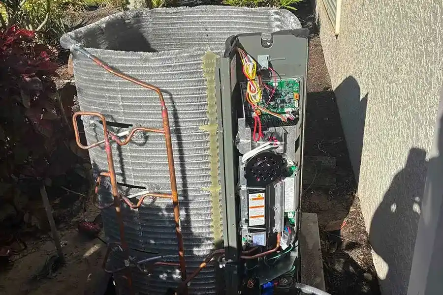 HVAC technician inspecting internal components during AC maintenance in Naples, FL