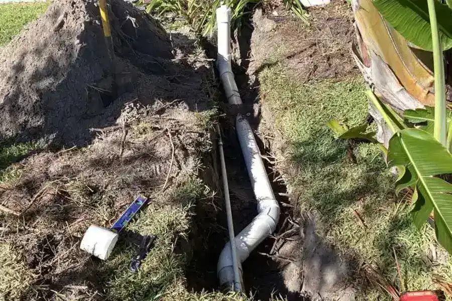 Residential drain pipe repair with exposed sewer piping in the ground