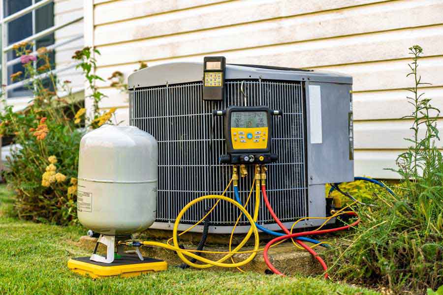 Commercial refrigerant leak detection service with pressure gauges on an exterior AC unit